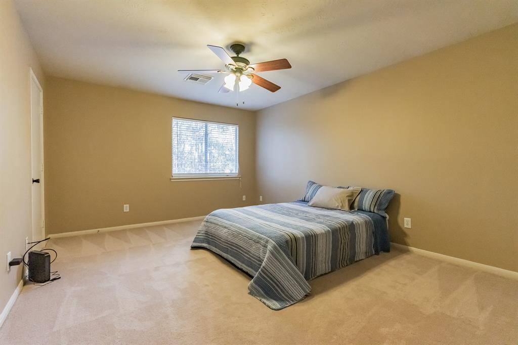 Pool table included!  Thegame room features a pool table, a modern ceiling fan, and a stylish black accent wall with bar seating. It's perfect for entertaining and relaxation.