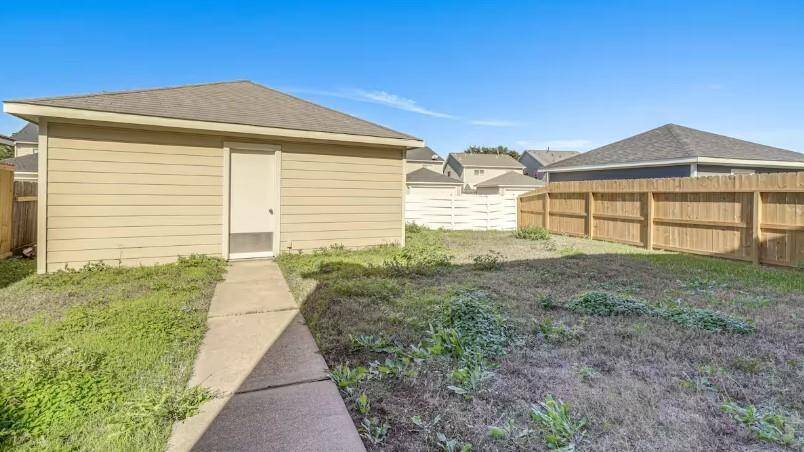 View of backyard and backdoor of garage  walkway leading to home