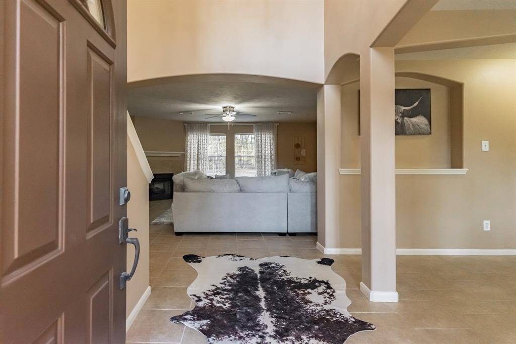 Welcome to a warm and inviting entryway featuring neutral tones, and natural light through the windows.