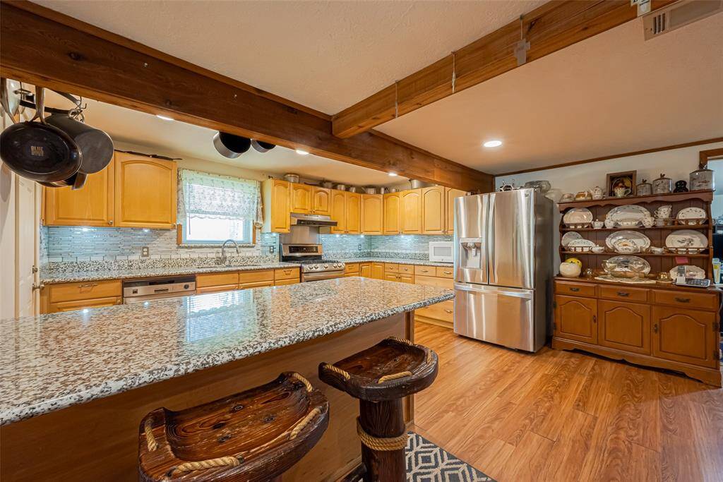 Gorgeous kitchen with granite countertops and lots of storage space.  Beautiful wood beam supports give that lovely farmhouse charm!