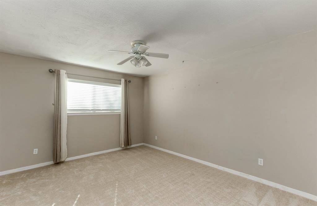Spacious bedroom with neutral colors, recent carpet, ceiling fan & spacious closet.