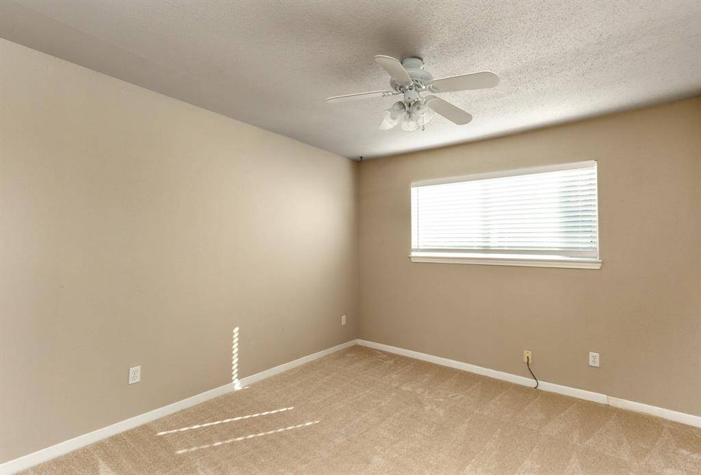 Spacious bedroom room with recent carpet, ceiling fan and spacious closet.