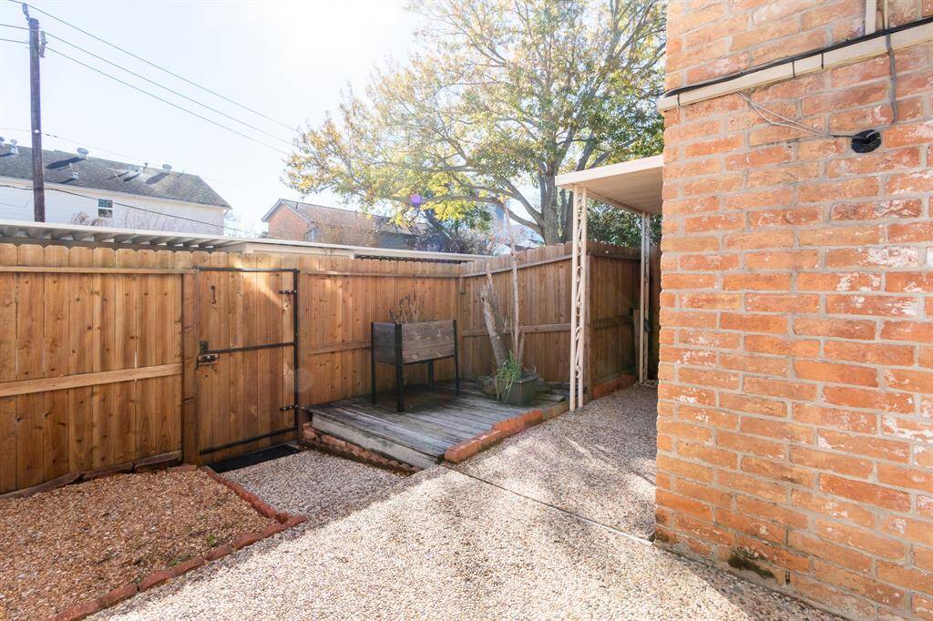 Another view of the back yard with gate leading to the 2 covered parking spots and outdoor storage.