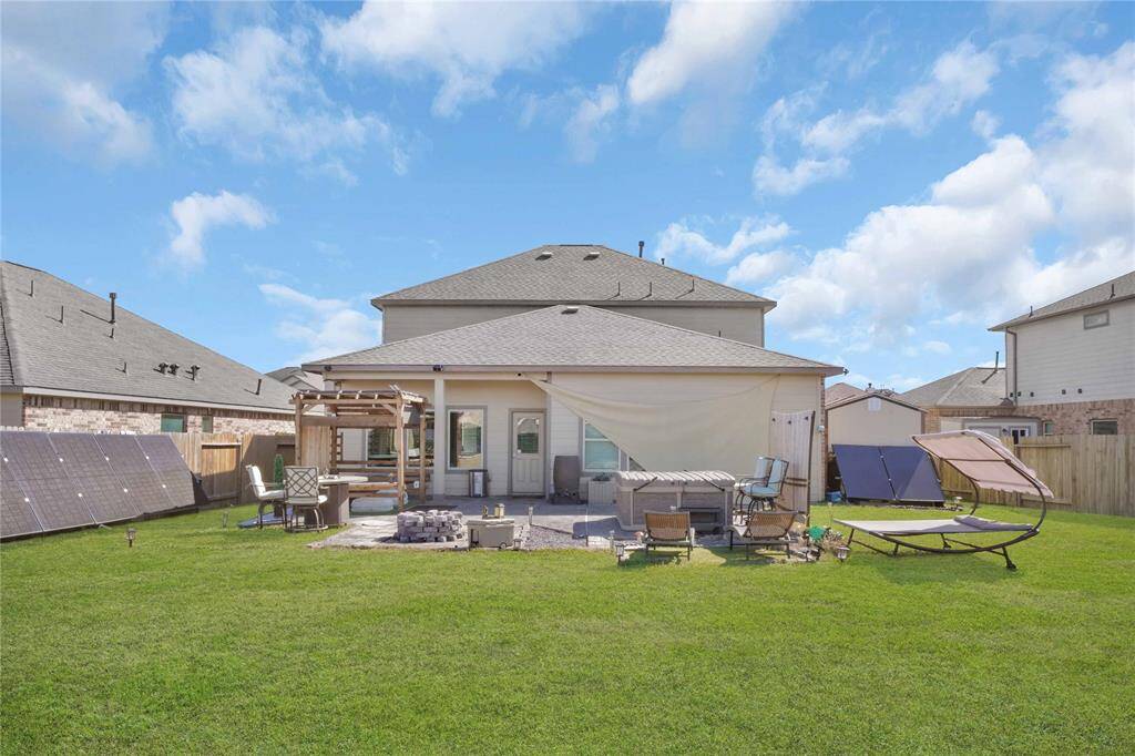 Back of house view. Hottub, firepit and pergola. This is a vibe at night! Prefect place to stargaze. Sunshade by windows blew down from storm, will be reattached or removed