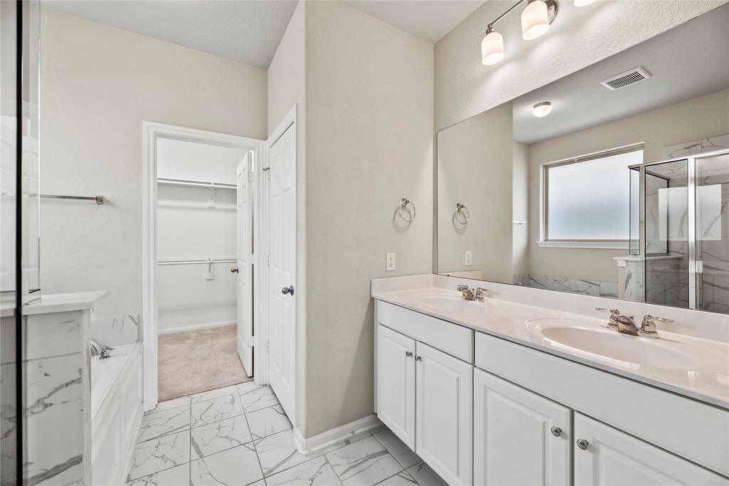 The primary bath offers dual vanities with plenty of storage.