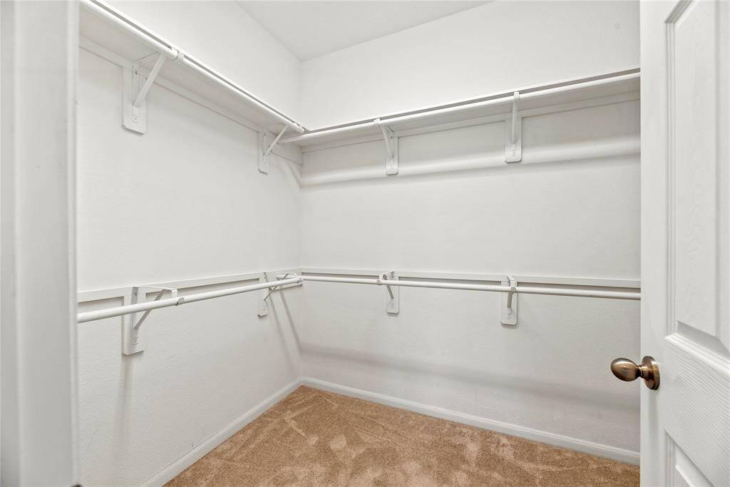 The primary closet offers ample space to store all your clothes and keep everything organized.