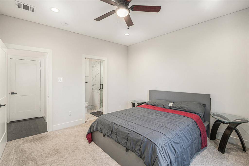 This bedroom features a modern design with neutral walls and carpet, a ceiling fan, and recessed lighting. Also includes on-suite bathroom.