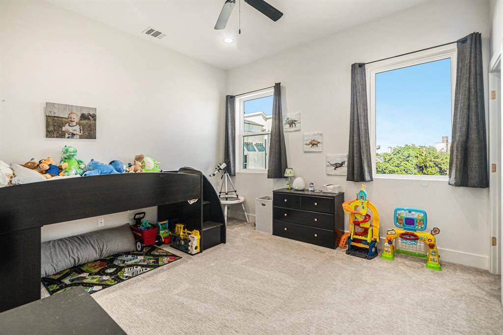 This bright room features two large windows and a walk in closet with a bathroom off to the side.