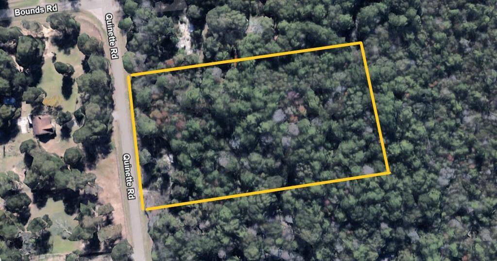 This aerial photo shows a wooded plot of land outlined in yellow, located along Quinette Rd near Bounds Rd. Ideal for privacy and surrounded by natural greenery.