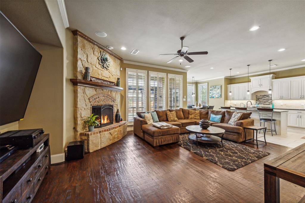 Family room with recess lighting, wired for surround, a fireplace, ornamental molding, ceiling fan, and hardwood floors. Lantana Golf Course