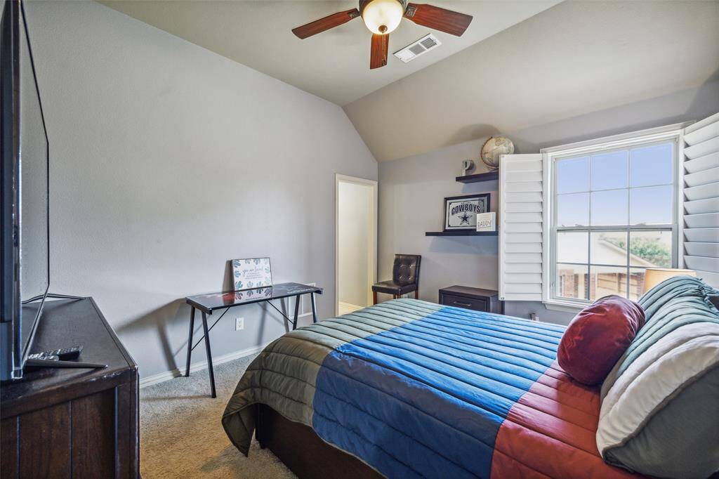 Bedroom with ceiling fan, lofted ceiling, and light colored carpet. Lantana Golf Course