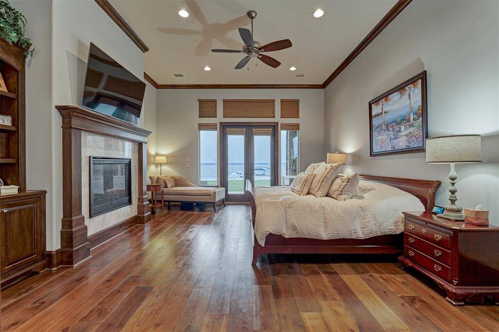 On the first floor, the primary bedroom suite features hardwood flooring, a gas fireplace and double doors leading to the back porch. The meticulous craftsmanship is showcased in the crown molding and coordinated mantle.
