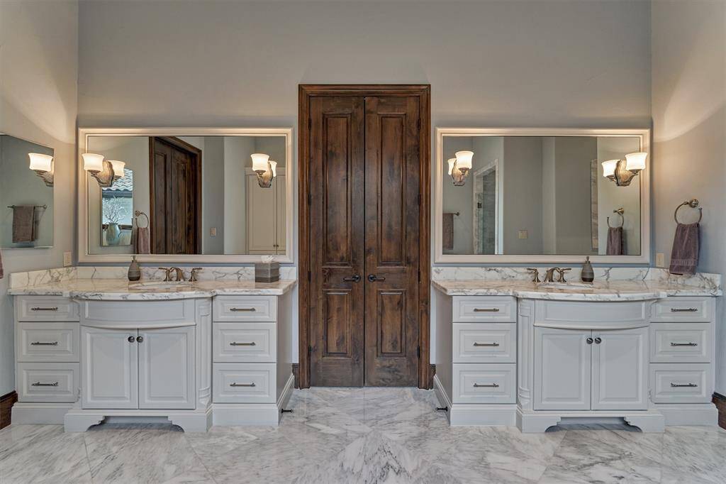 The primary bath has two custom bow front vanity areas with two separate walk-in closets.