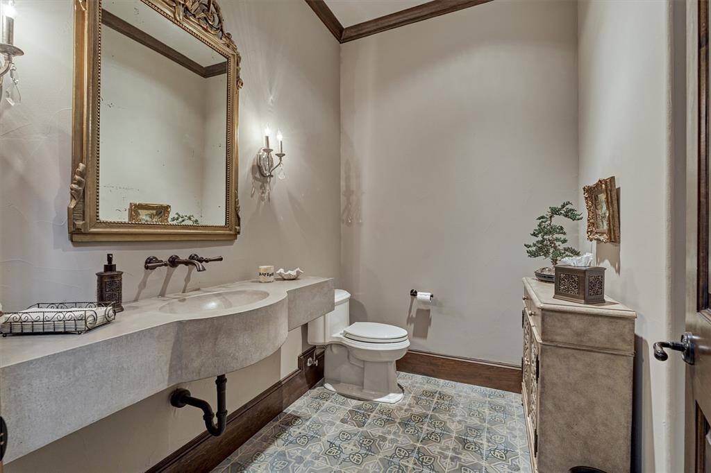 A stunning powder bath on the first floor has been finished out with antique Mexican floor tile and a custom concrete floating sink.