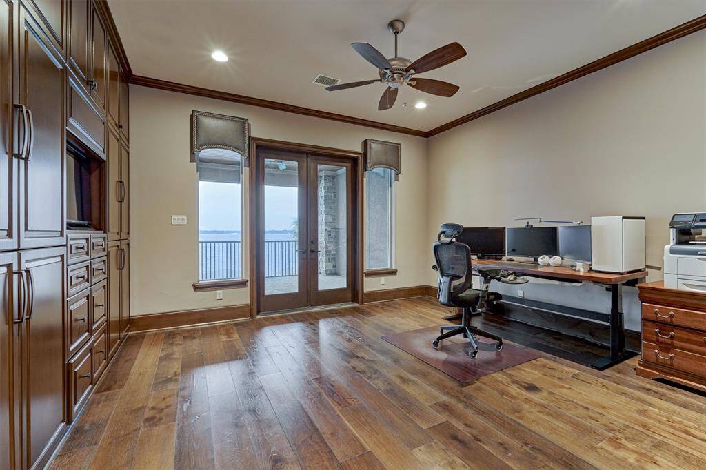 The office on the second floor has been cleverly designed to also function as a bedroom. The built-ins on the opposite wall can serve as both office storage or closet space with hanging rods and drawers. Double doors open to the balcony on the second floor.