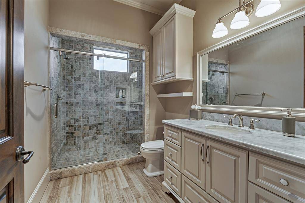A full bath is located off of the second floor office with a seamless glass shower door and beautiful cabinetry.