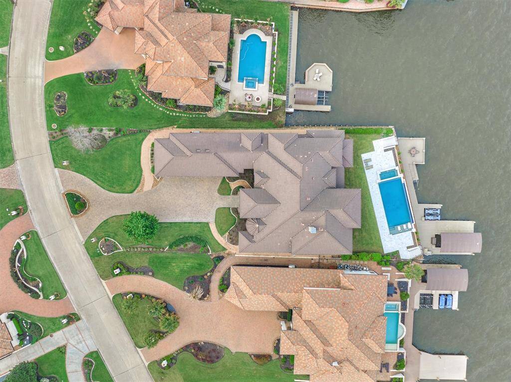 Aerial view of the property shows the extra parking with circle driveway and perfectly positioned home to take advantage of the open water views of the lake.