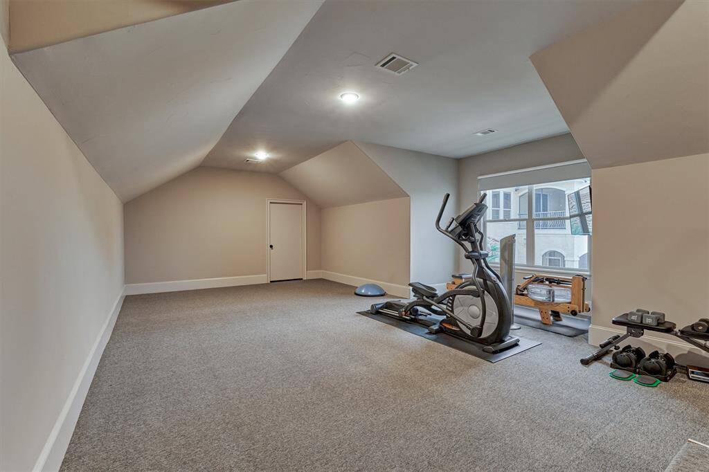 This room has been finished out for a home gym or 6th bedroom. An additional door at the opposite end provides access to the floored attic space with tons of storage!