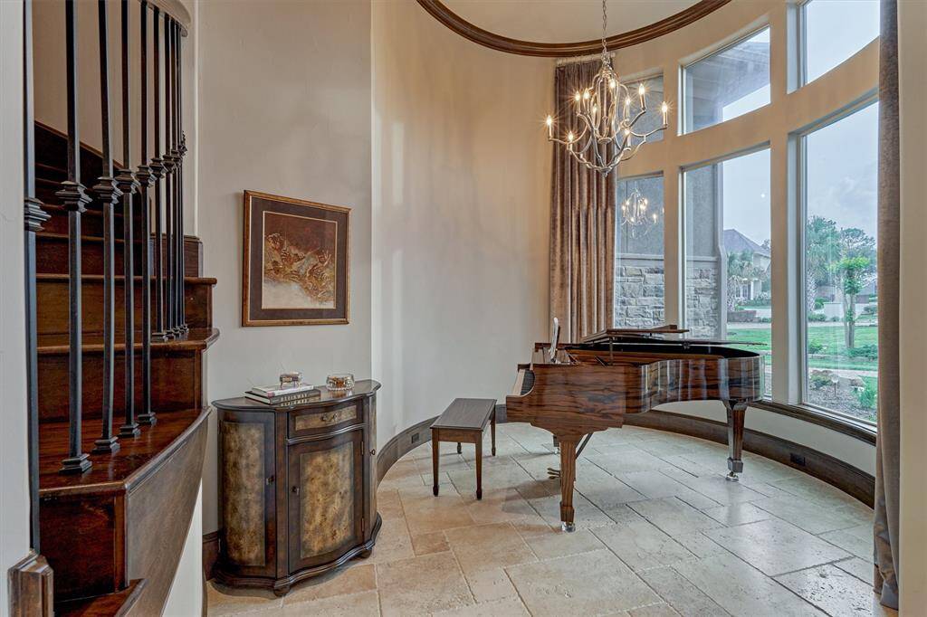 The room to the right of the entry was designed as a piano room. The curved window overlooks the front yard and adds architectural interest. This space could also be an extra sitting room or wine tasting room.