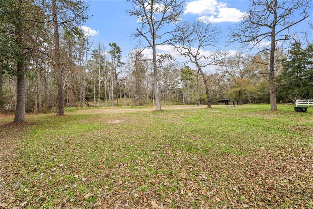 Left side of property located to left of white fence... property line ends right where the metal barn is