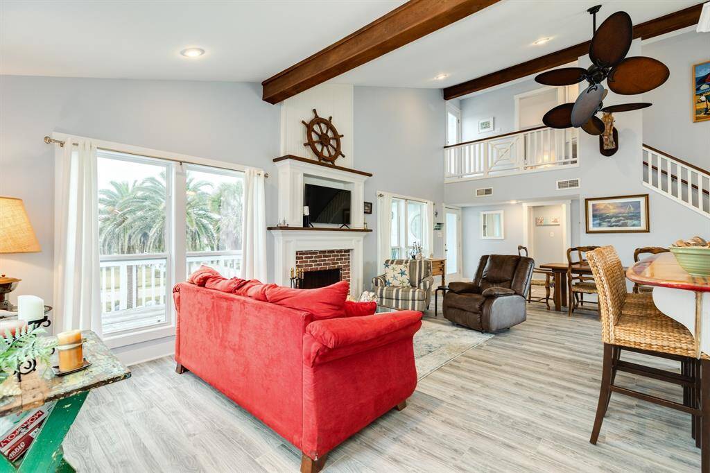 The main level features a high ceiling with exposed beams providing an open, "airy" space.