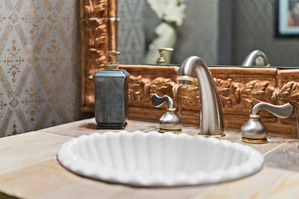 Pretty guest half-bath vanity features a shell sink with slate counter. Be sure to look at all the unique features throughout this custom home.