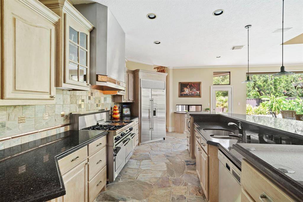 Gourmet kitchen features high-end Wolf gas range, Sub-Zero refrigerator, and Bosch dishwasher.