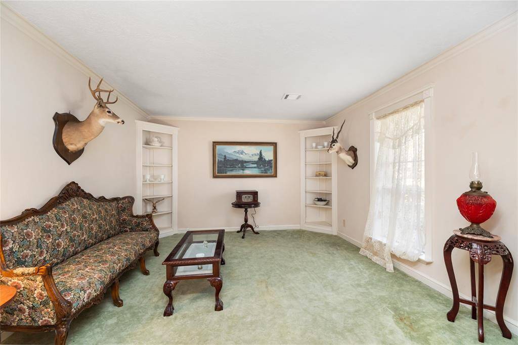 The Formal Living Room is situated at the front of the home, with built-in shelving in the corners of the room