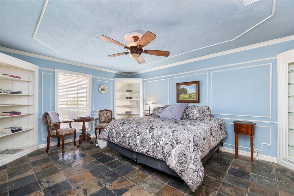 The Primary Bedroom also features slate floors and built-ins, along with lovely paneled walls and a cozy fireplace