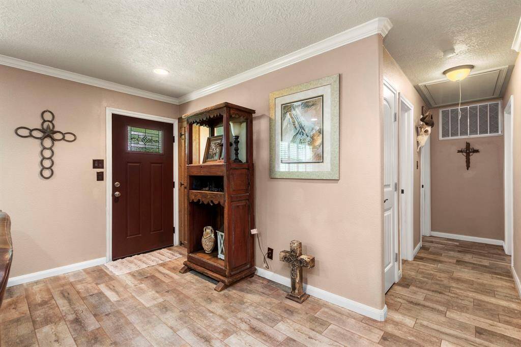 Reverse view from Living room toward entry door. Hallway leads to secondary bathroom and two secondary bedrooms, one of which has a 1/2 bath.