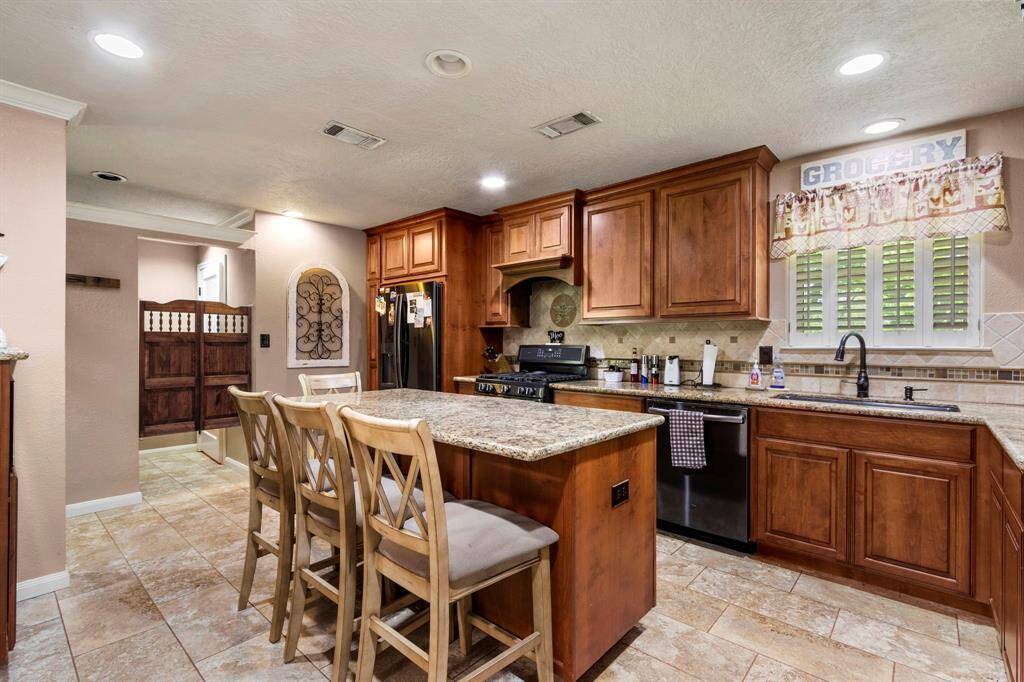 Swinging doors in background open to utility room and butler's pantry. No stone was left unturned in executing this kitchen transformation.