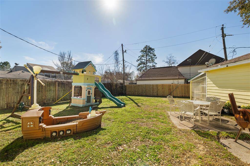 The backyard is spacious, with a patio area and raised garden bed.