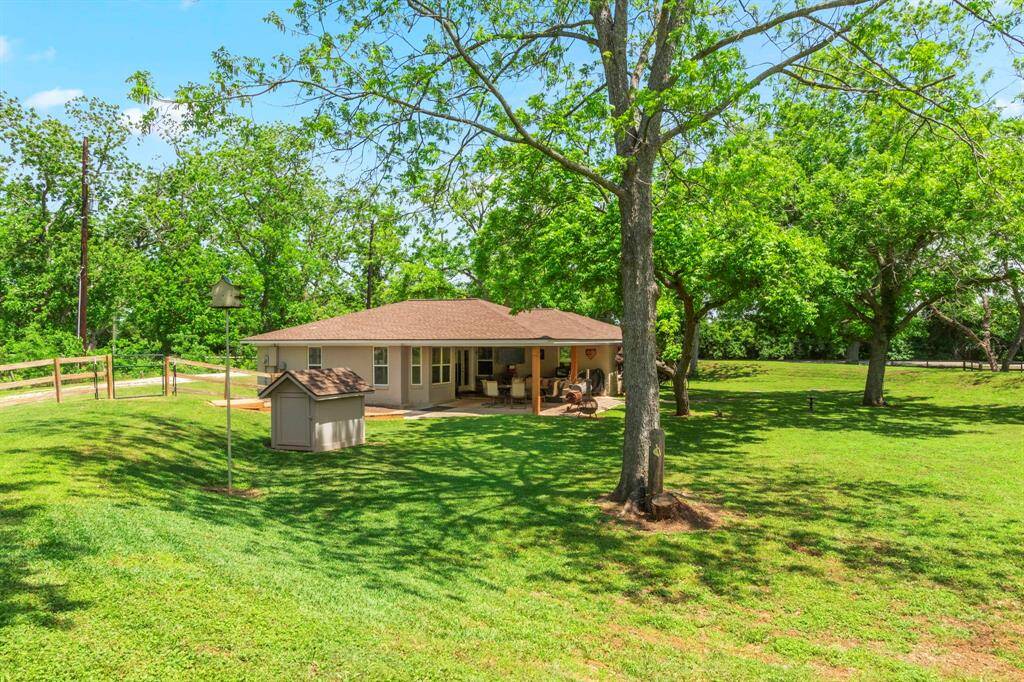 Home viewed from the back. Small structure is the well house which opens front and back for easy access. Home and large covered patio is usually embraced by shade from a few of the mature trees. Very tranquil and peaceful setting.