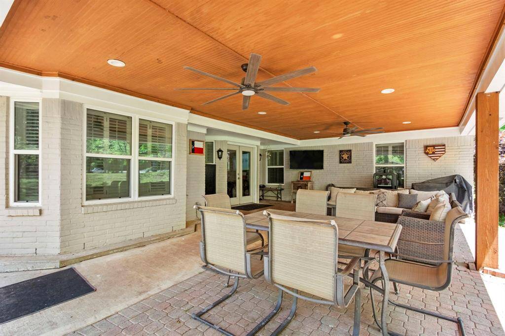 Covered patio features beaded board ceiling with two ceiling fans and six can lights. Paver stone base.