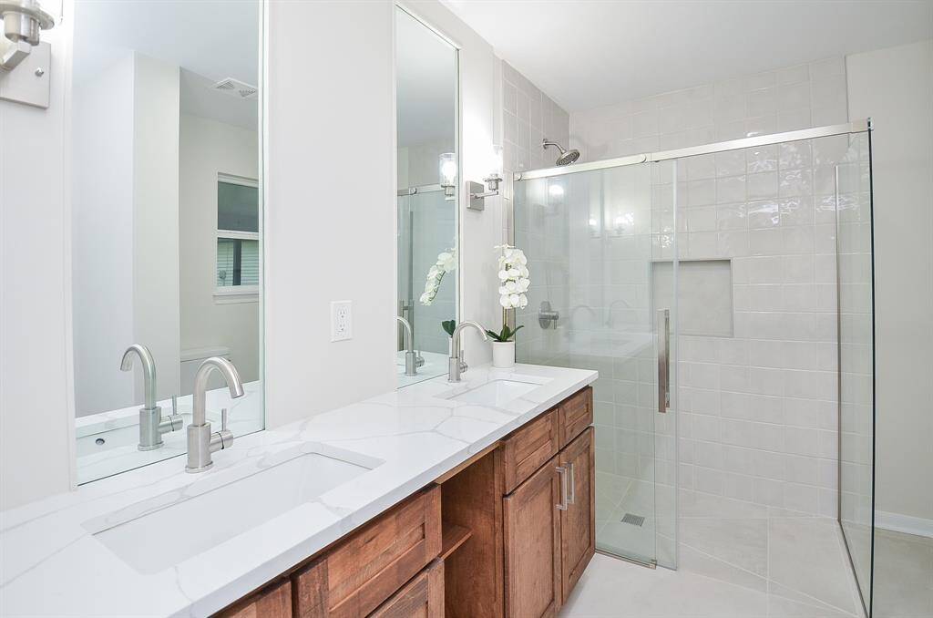 Primary bathroom with double vanity and curbless shower