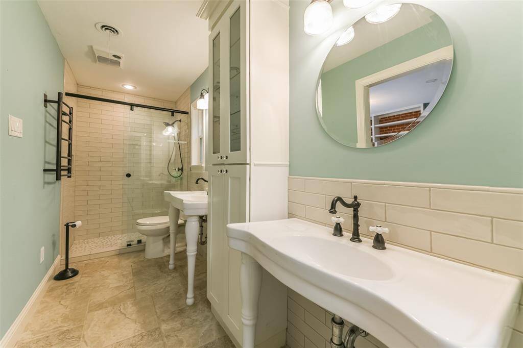 primary bathroom with walk in shower and towel warmer
