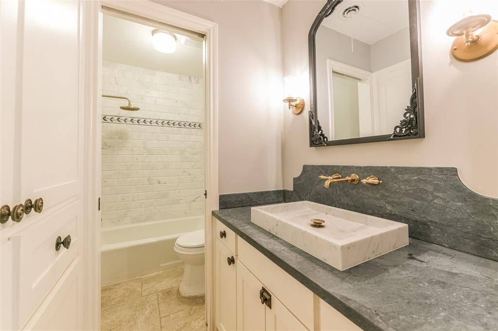 second bathroom with bathtub and custom built in cabinets/ soapstone countertop and marble sink