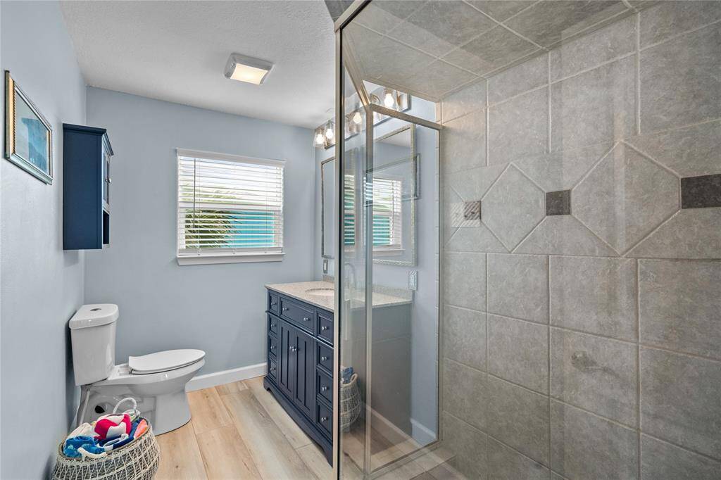 2nd bathroom, located off the hallway, Beautiful glass shower surround, custom tile.