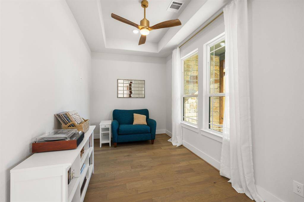 The home office or flex space is ideally located off the front door & offers both privacy & accessibility. Lg windows flood the room w/natural light, creating a bright & inviting atmosphere perfect for productivity or creative pursuits. The elegant tray ceiling adds a touch of architectural sophistication, enhancing the room's sense of openness & adding to the overall spacious feel. Whether you need a dedicated office, a quiet reading nook, or a playroom, this space can be easily tailored to suit your needs