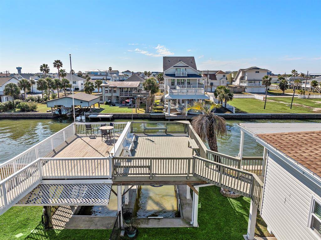This image showcases the expansive upper-level deck perched above the boathouse, offering panoramic canal views and a breezy, sun-soaked setting for outdoor lounging or dining.