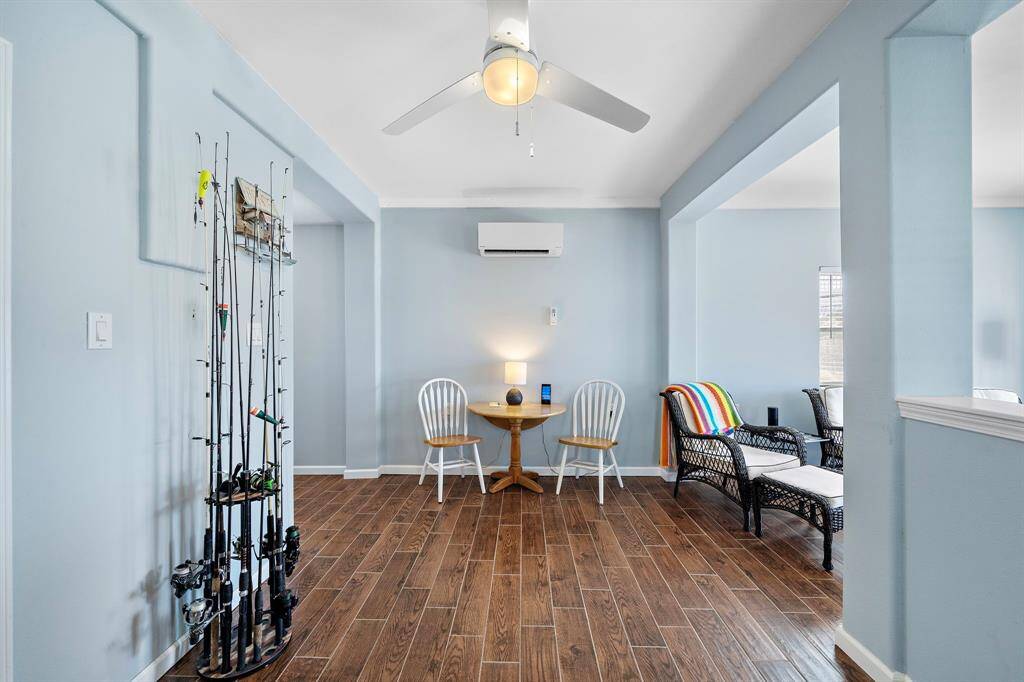 The sitting area of the in-law suite is inviting and thoughtfully designed, with a cozy café table, wicker chairs, and soothing coastal blue walls. The perfect spot for morning coffee or a game of cards.