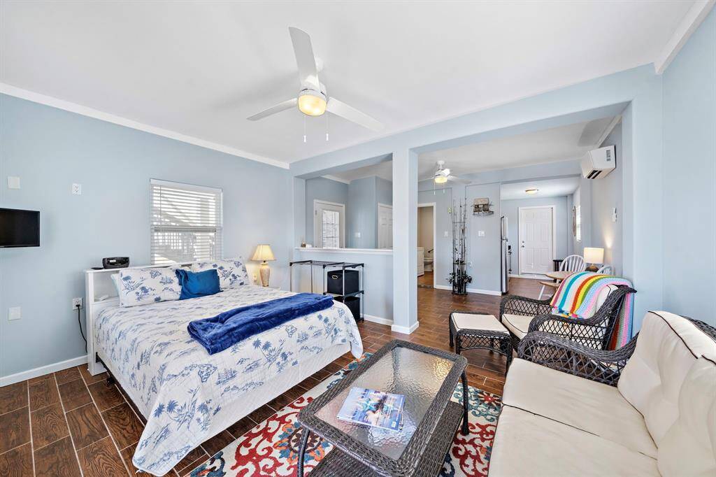 This open-concept sleeping and living area includes a king-sized bed, seating space, and direct views of the waterfront through large sliding doors, combining comfort with a scenic backdrop.