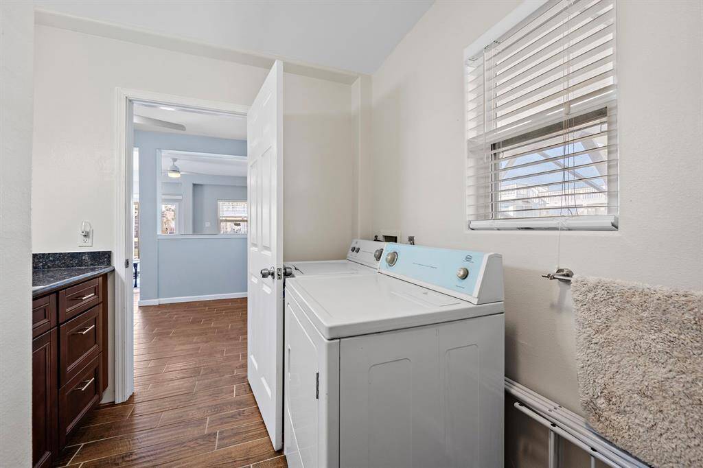 A dedicated laundry area inside the in-law suite offers convenience with a washer and dryer set, ample natural light from the window, and easy access to the living quarters.