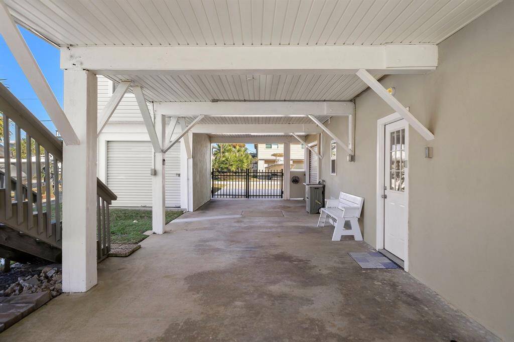 Another angle of the covered space under the home, looking out toward the front gate and driveway. This space is versatile for storage, carport parking, or even outdoor gatherings.