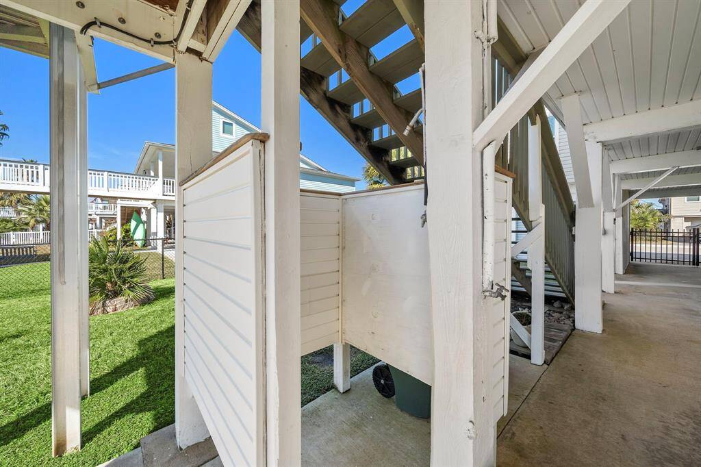 An outdoor shower tucked under the stairs leading up to the main deck—perfect for rinsing off after a day at the beach or on the boat.