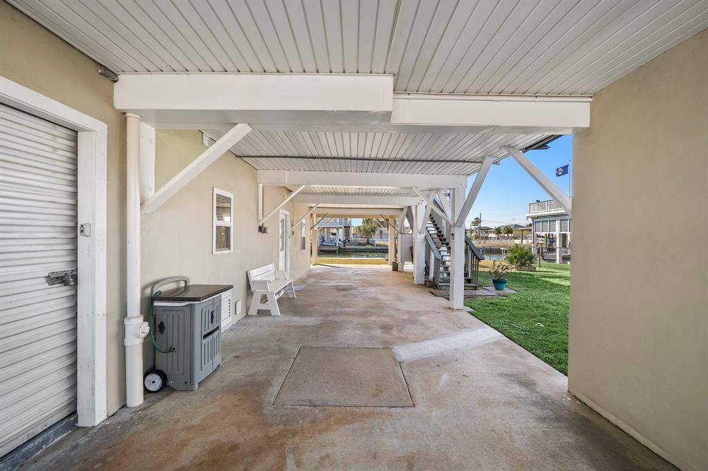 Underneath the home, a spacious covered area ideal for entertaining, parking, or relaxing in the shade. The space is clean and well-maintained, with a bench and plenty of storage potential.