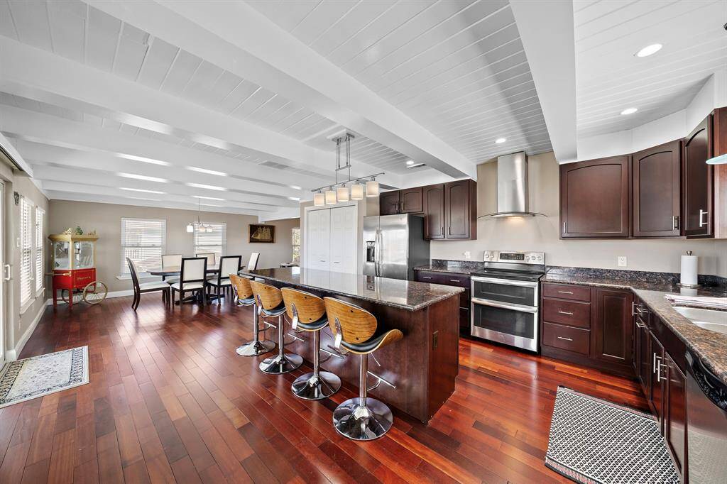 A wider view of the well-designed kitchen, with rich cabinetry, modern appliances, and a show-stopping granite island. This space brings family and friends together in the heart of the home.