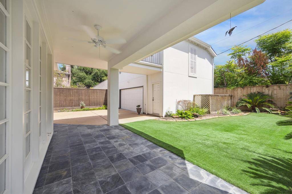 Expansive back yard framed by shrubs, plants, blooming flowers and a decorative flagstone pathway. This photo, taken from the south boundary line fence, shows what a great playscape this is while soaking up the sun. Incorporate your outdoor seating for ultimate enjoyment!