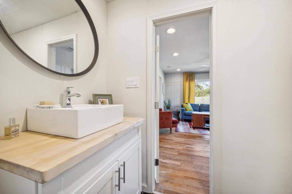 Currently used as an exercise room, Bedroom #3 is full of natural light, and features a Sputnik-style light fixture, recessed lighting, hardwood flooring, and adjoining bath.