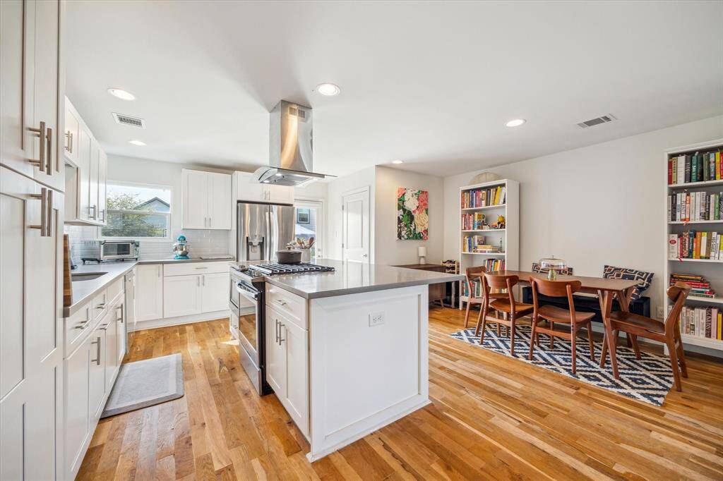 This primary suite features an abundance of natural light thanks to the walls of windows. The modern ceiling fan and recessed lighting create a comfortable ambiance, while the generous walk-in closet and ensuite bathroom provide convenient functionality.